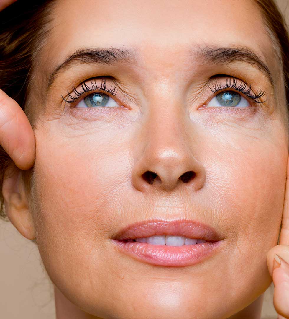 Cosmétologue effectuant un traitement du visage et appliquant un masque facial